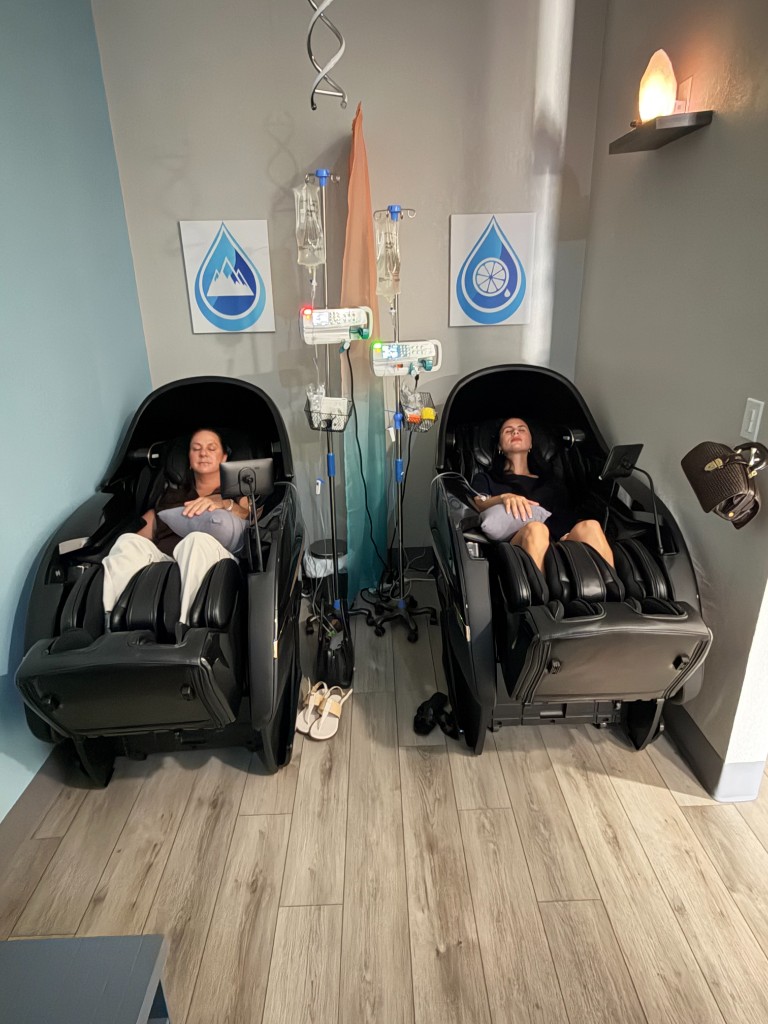 Two clients relaxing in zero-gravity massage chairs during IV therapy at Prime IV Palm Harbor